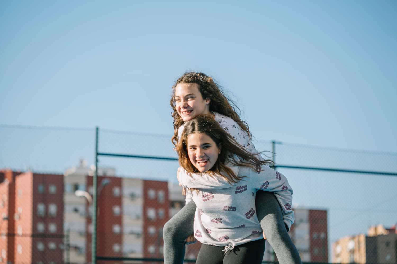 Dos jóvenes riendo en la azotea de un edificio